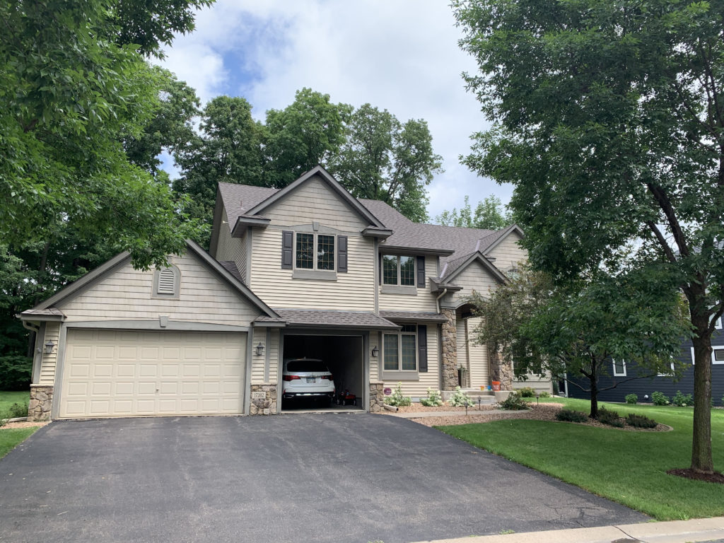 A two story home in Minnesota with new brown vinyl siding.