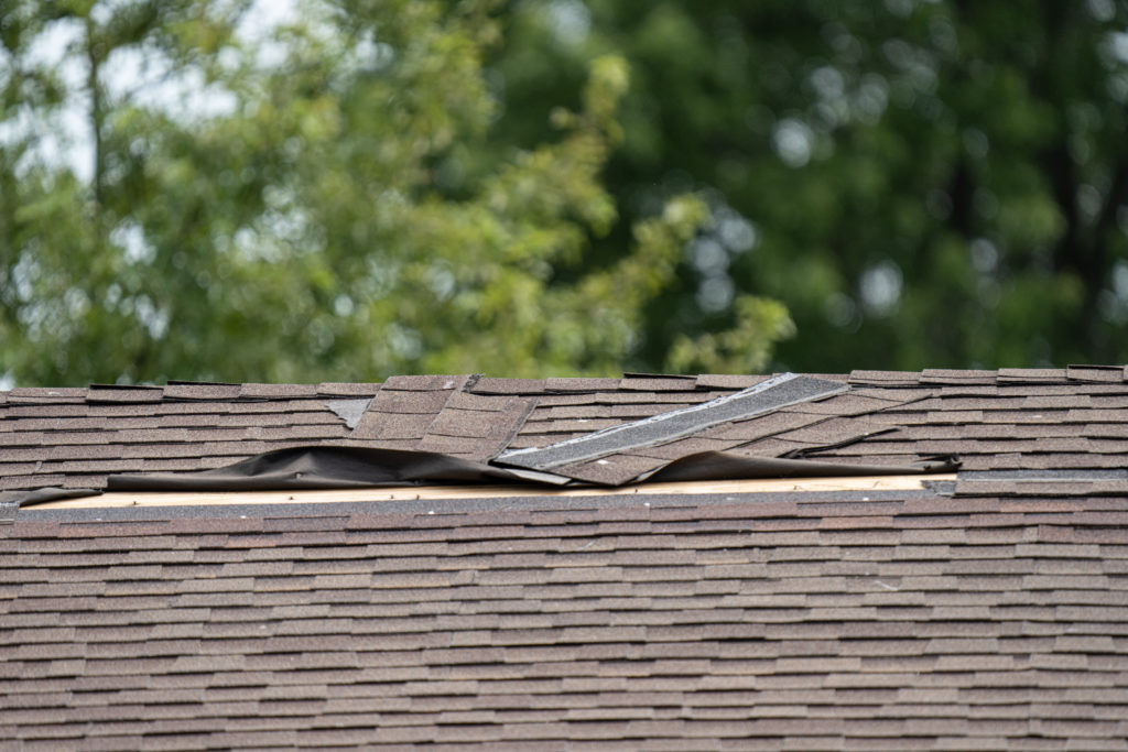 Closeup image of a damaged roof after a storm.