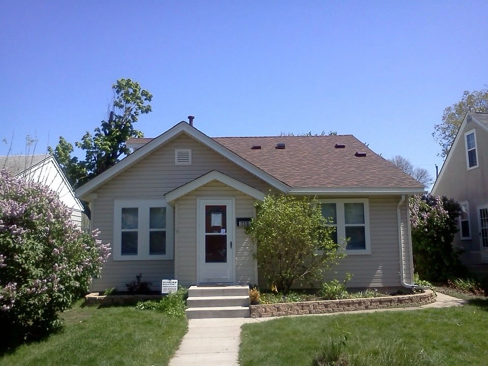 A home with a new asphalt shingle roof installed by Midwest Roofing, Siding & Windows.