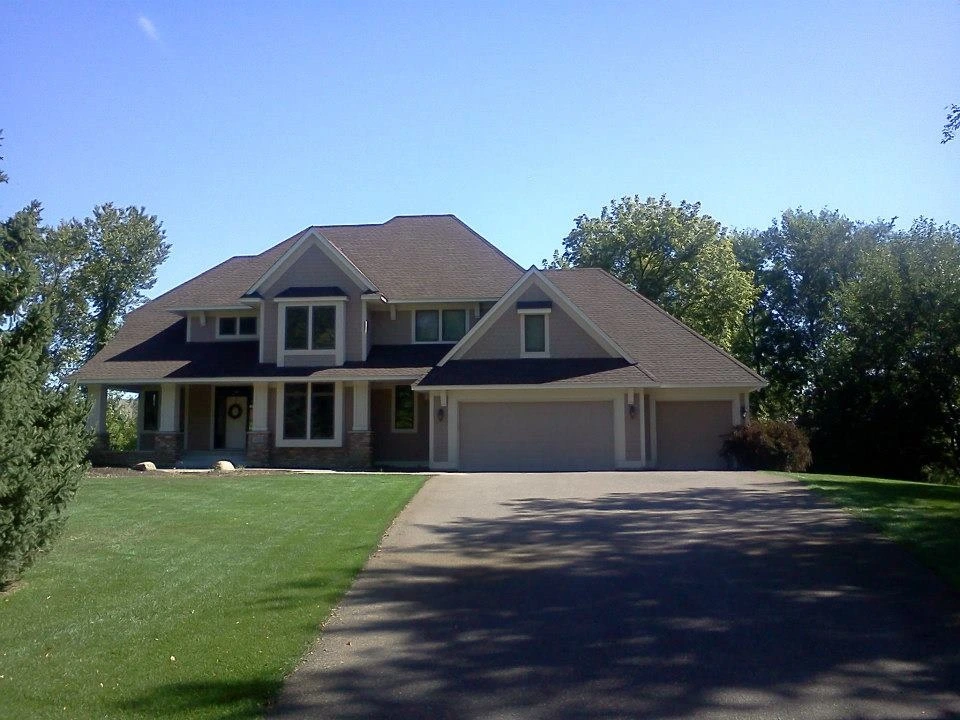 A home near Minneapolis with a new asphalt shingle roof installed by Midwest Roofing, Siding & Windows.
