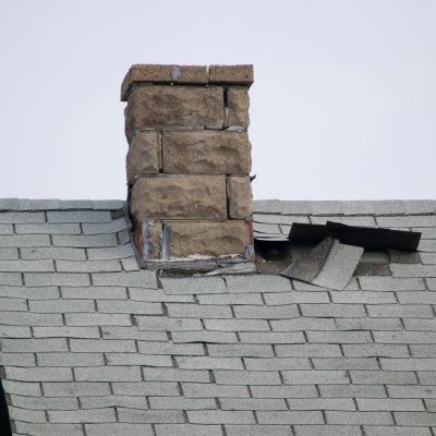 older shingle roof with shingles blown off