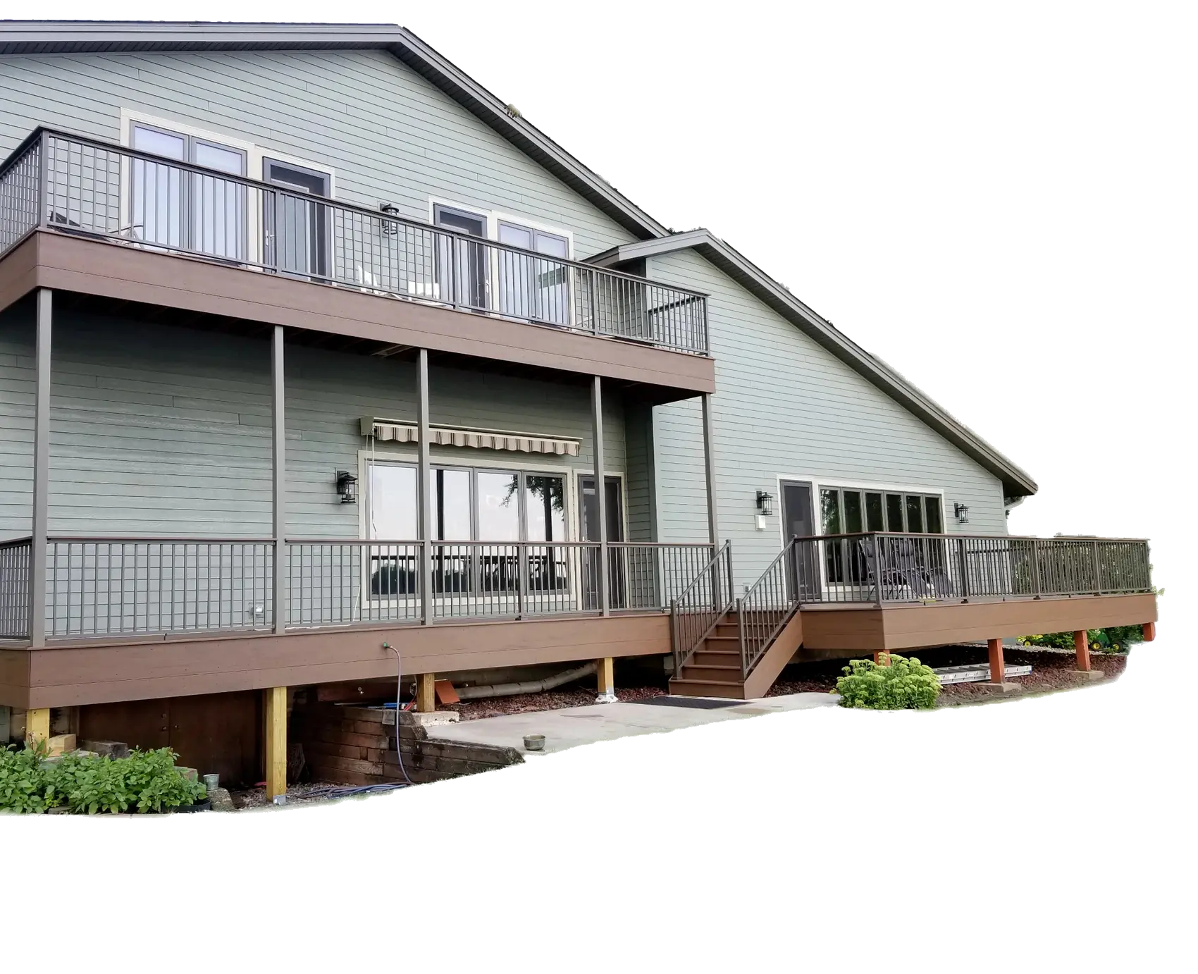 A 2 story home withe green siding and a balcony.