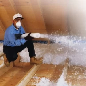 Contractor in attic blowing in insulation